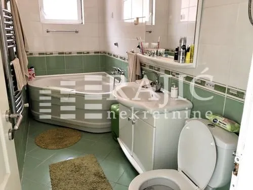 Small bathroom with a corner bathtub, vanity, and toilet.