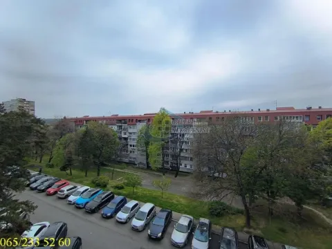 Pogled sa prozora na okolne zgrade, parking sa parkiranim automobilima i zelene površine. - image 8