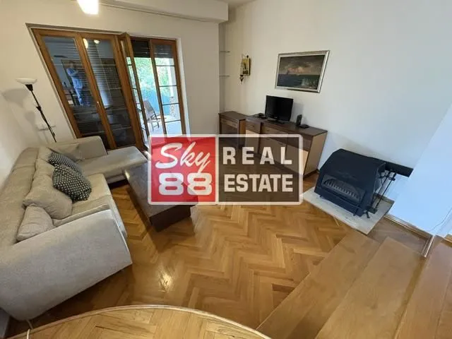 Living room with a sofa, fireplace, and access to the terrace.