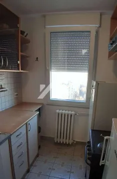 Smaller kitchen with a window, cabinetry, and a refrigerator. - image 3