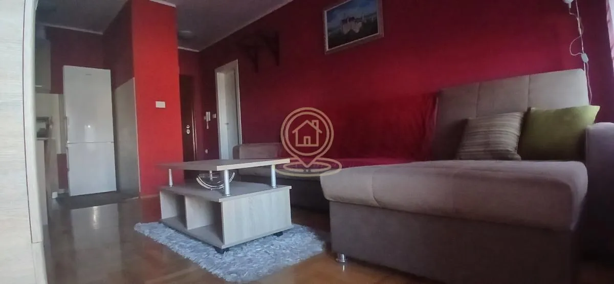 Living room with a corner sofa, coffee table, and red walls.