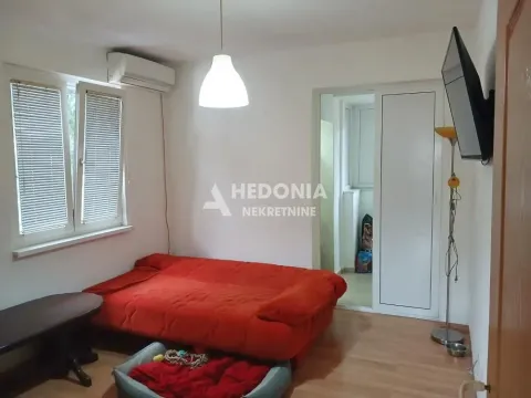 Manja spavaća soba sa crvenim krevetom i klima uređajem. - image 2
