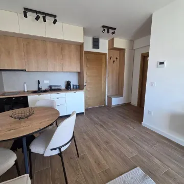 Modern kitchen with a dining area and wooden elements in the interior. - image 3