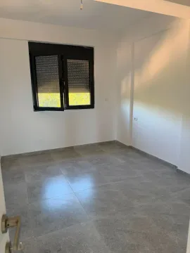 Prazna soba sa sivim pločicama na podu i crnim prozorom. - image 7
