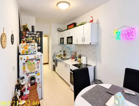 Smaller kitchen with white cabinets and a dining table in the foreground. - image 4