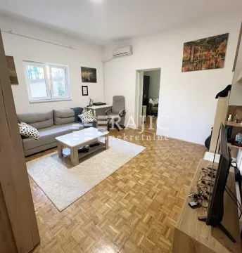 Living room with a sofa, desk, and parquet flooring. - image 4
