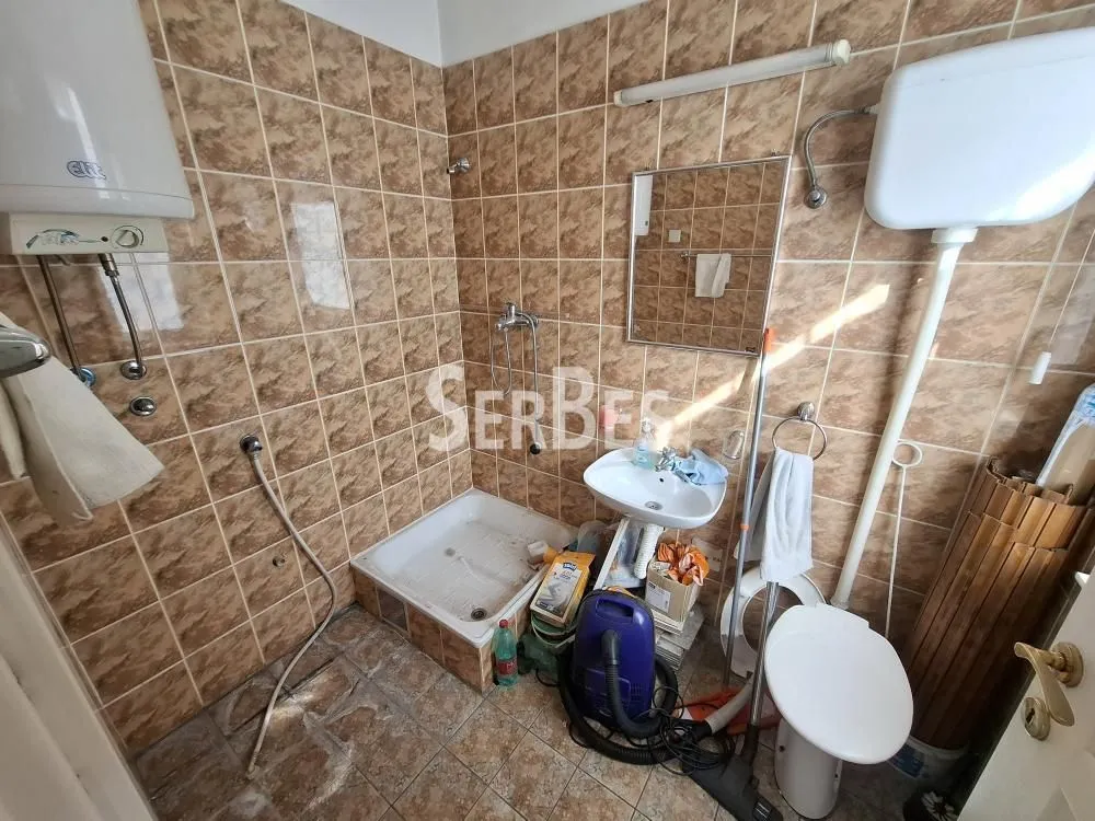 Kupatilo obloženo keramičkim pločicama sa tuš kabinom, umivaonikom i toaletom.
