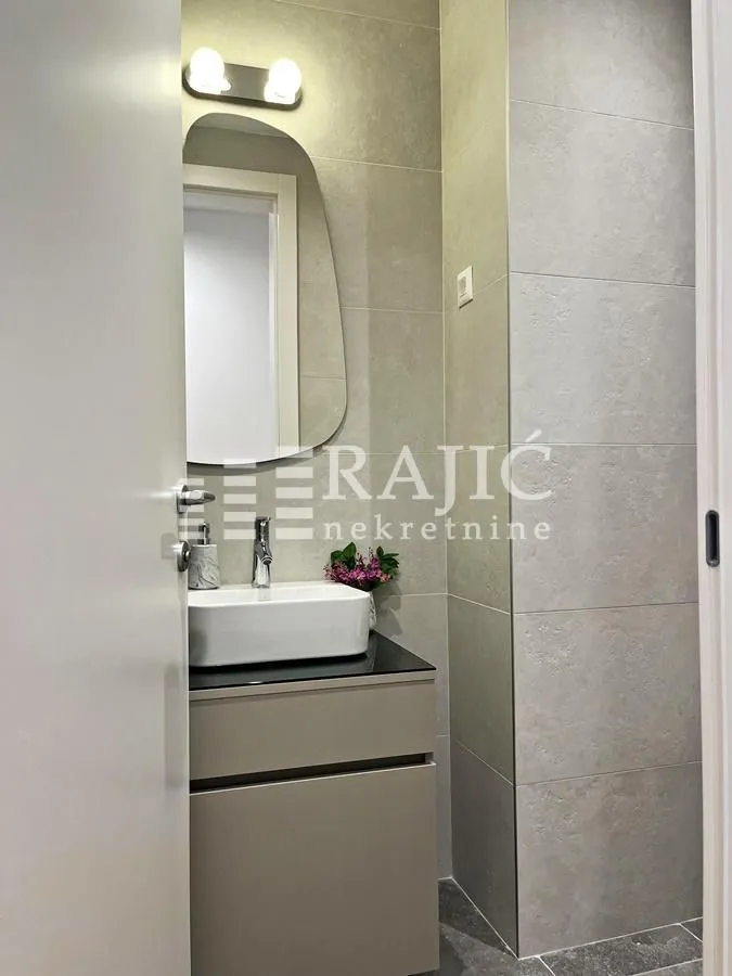 Modernly equipped bathroom with a washbasin and mirror.