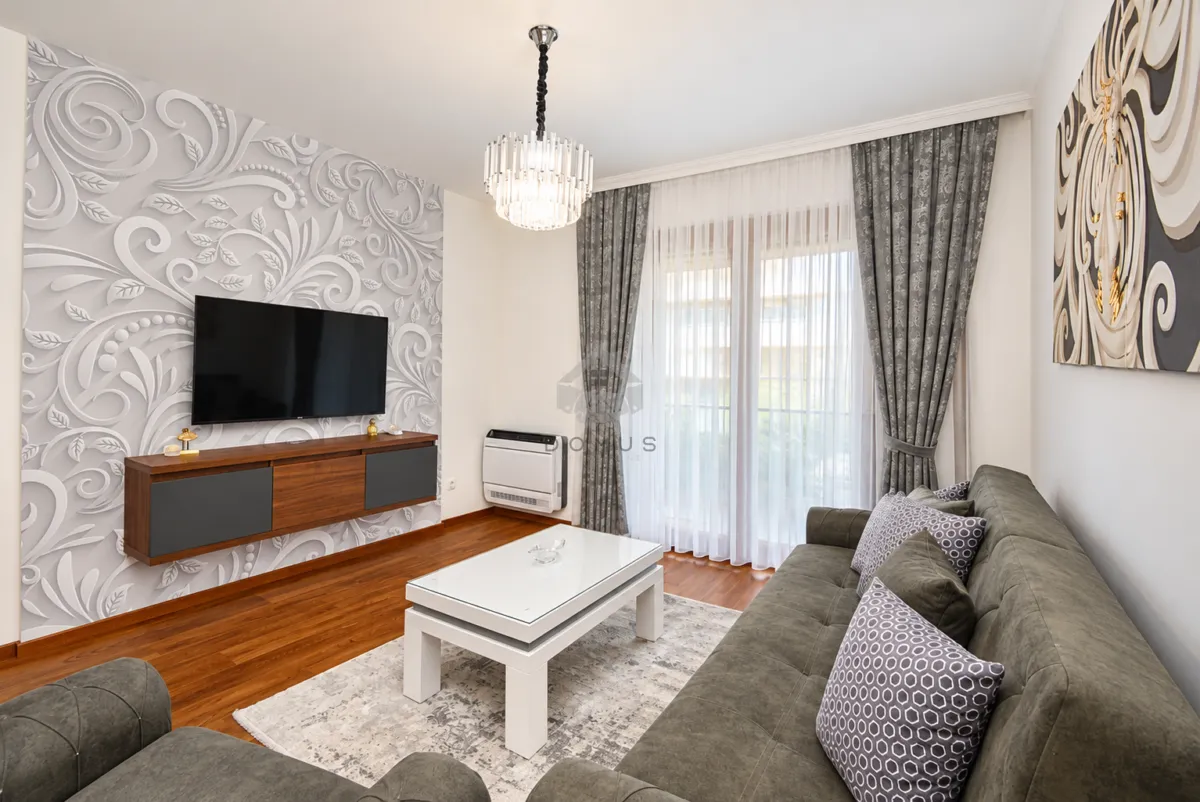 Living room furnished with a sofa, television, and coffee table.