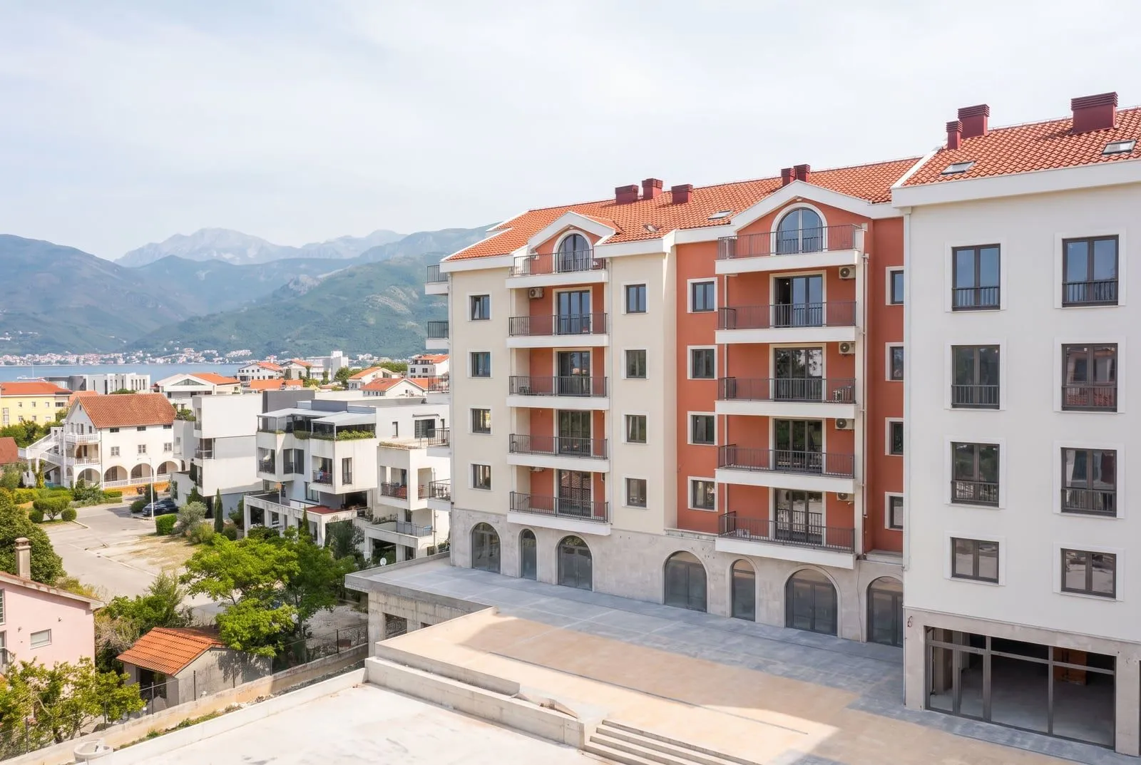 Vanjski izgled moderne stambene zgrade sa pogledom na planine i more.