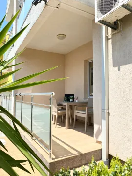 Covered terrace with a table, chairs, and metal railing. - image 4