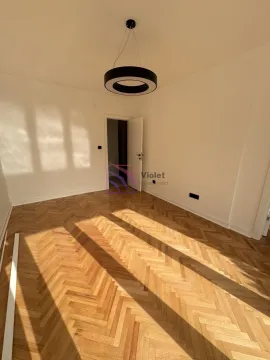 Prazna soba sa parketom i modernim lusterom. - image 2