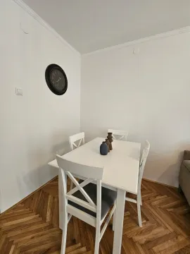 Bijeli trpezarijski sto sa stolicama u uglu prostorije. - image 4