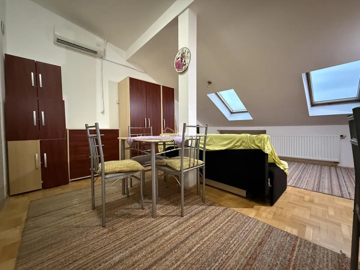 Living room with a dining table and roof windows in the attic.