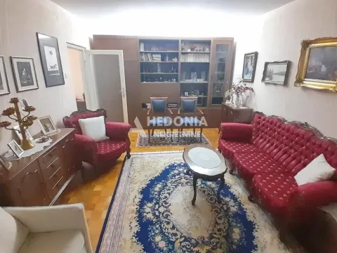 Tradicionalno opremljena dnevna soba sa crvenim garniturama i policama za knjige. - image 12