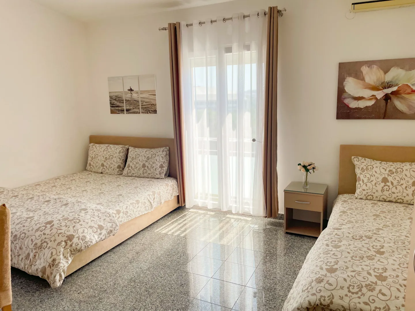 Bedroom with two beds and access to the terrace.