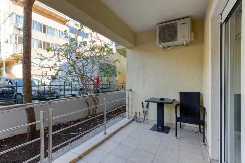 Covered balcony with a table, chair, and air conditioning unit. - image 25