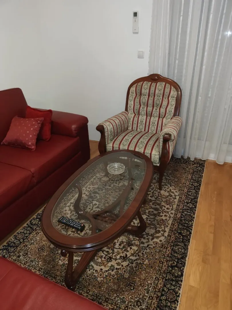 Living room featuring a red sofa, an armchair, and a wooden coffee table.