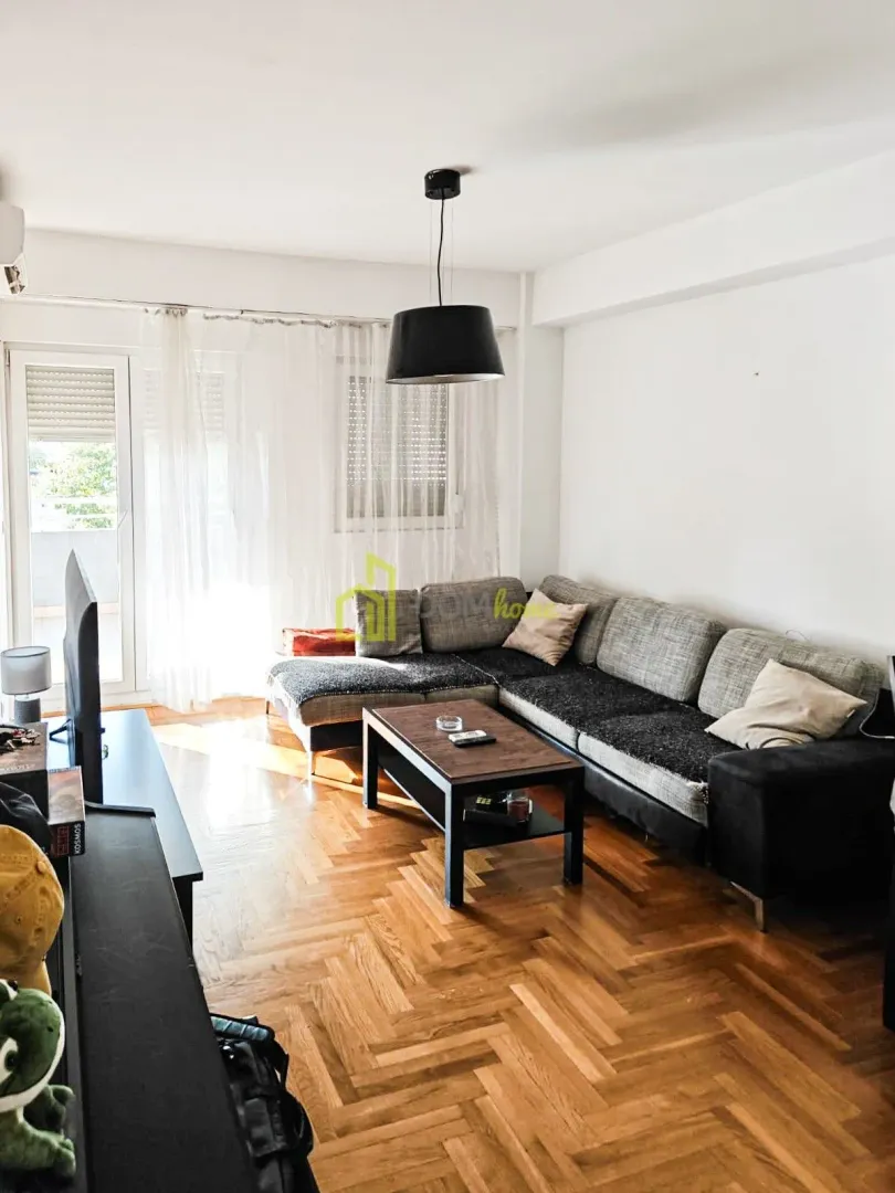 Living room with a large sectional sofa, coffee table and television.