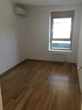 Empty room with wooden flooring, an air conditioning unit, and a window. - image 7