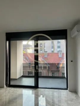 View from the room through large glass sliding windows to the terrace and surrounding buildings. - image 11