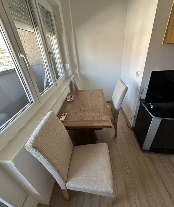 Dining table with chairs near the window in the living room.
