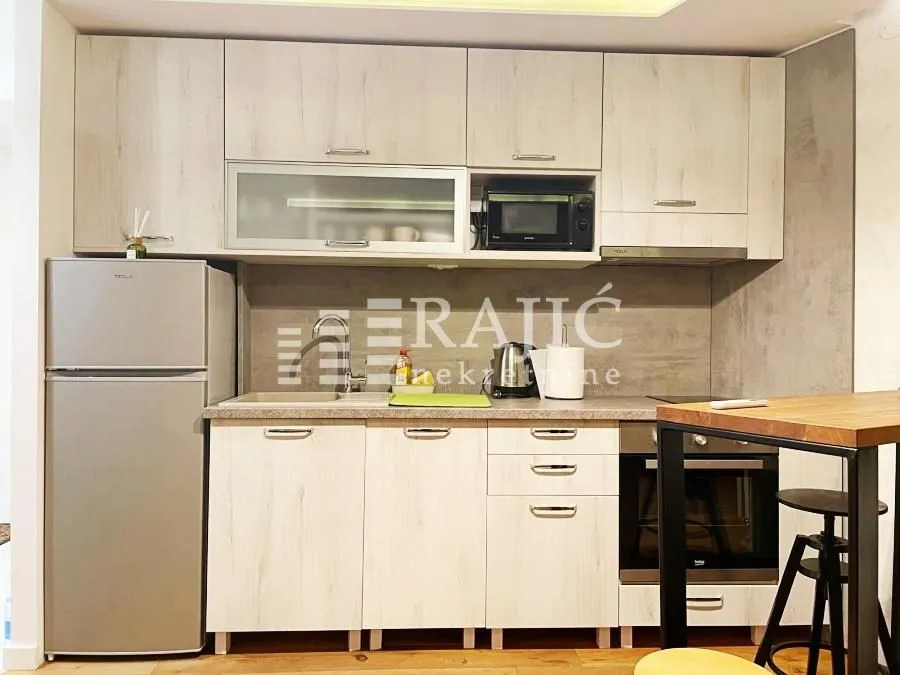 Modern kitchen with wooden cabinetry and built-in appliances.