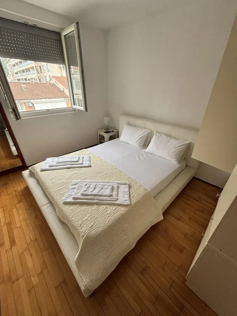 Bedroom with a double bed and a window overlooking the city.