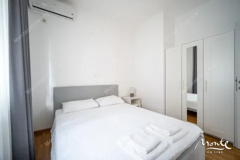 Bright bedroom with a double bed, white wardrobe, and air conditioning. - image 26