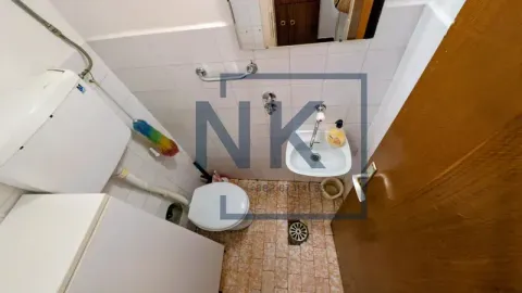 Small bathroom with toilet, washbasin, and tiled walls. - image 15