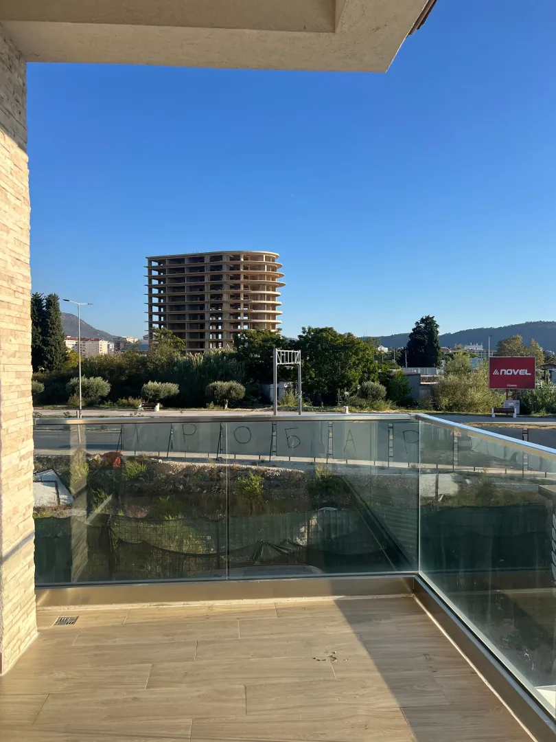 Modern balcony with a glass railing and a view of the surroundings.