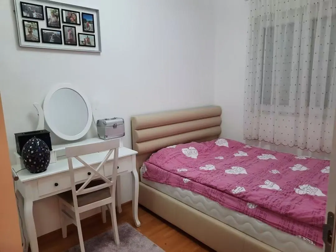 Bedroom with a bed, vanity table, and window.