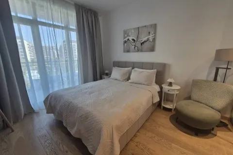 Nameštena spavaća soba sa bračnim krevetom, foteljom i izlazom na balkon. - image 2