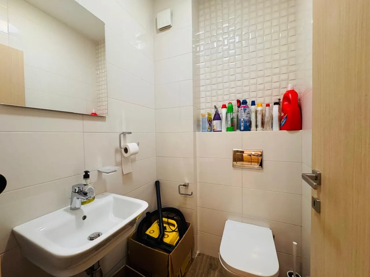 Small bathroom with a sink, toilet, and mirror.