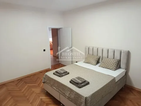 Furnished bedroom with a double bed and parquet flooring. - image 13