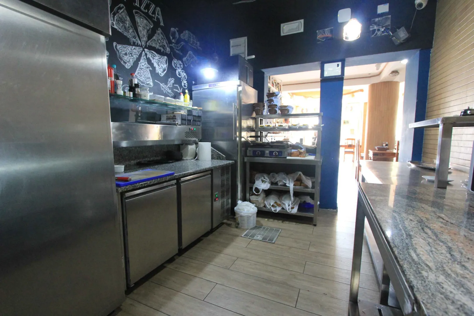 Commercial kitchen with stainless steel appliances and work surfaces.