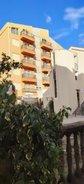 Exterior of an apartment building with balconies and a yard. - image 3