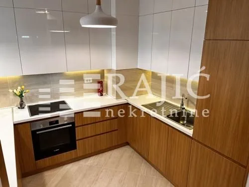 Modern kitchen with white cabinets and wooden details.