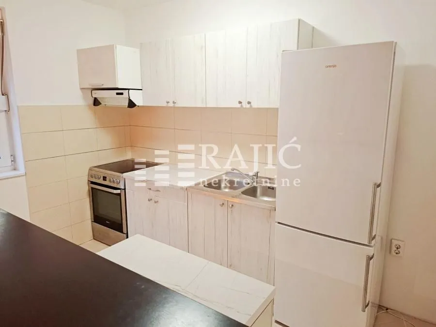 Smaller kitchen with white cabinets, stove, and refrigerator.