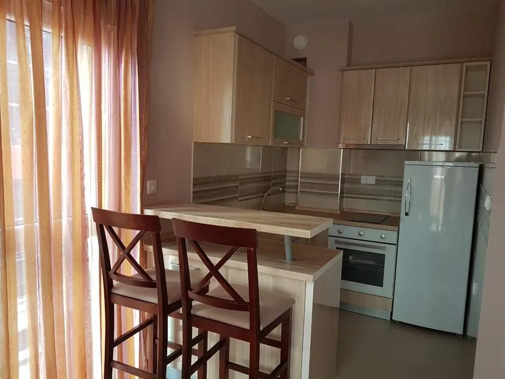 Smaller kitchen with a breakfast bar, wooden cabinetry, and built-in appliances.