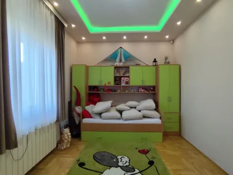 Children's bedroom with a bed, green furniture, and a drop ceiling with lighting. - image 26