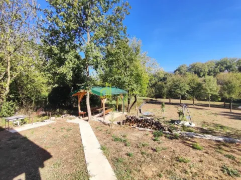 Green yard with a wooden gazebo, pathway, and landscaped relaxation area. - image 15