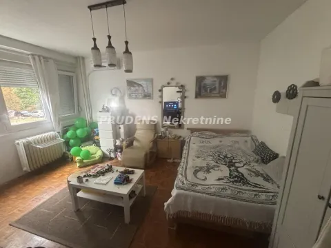 Nameštena spavaća soba sa krevetom, foteljom i manjim stolom. - image 2