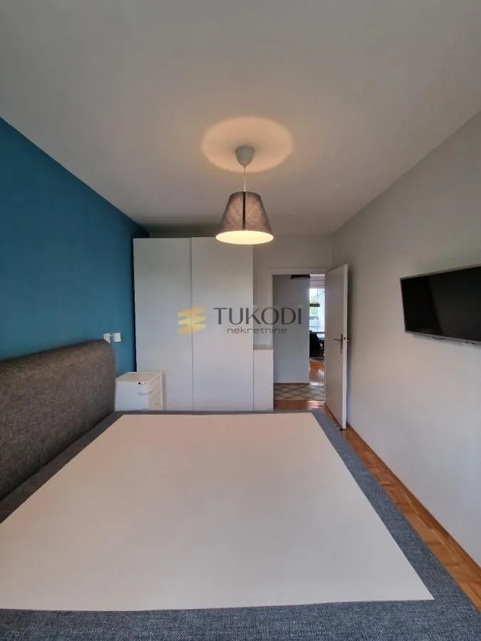 Bedroom with a double bed, wardrobe, and a wall-mounted TV.