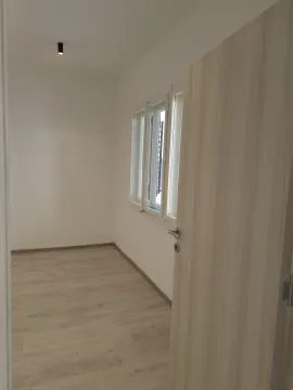 Empty room with light laminate flooring and an open door. - image 3