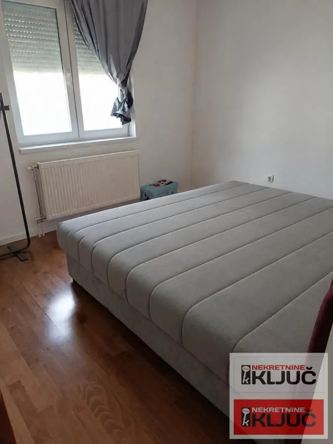 Spavaća soba sa bračnim krevetom i prozorom.