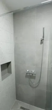 Modern walk-in shower with grey tiles and chrome fixtures. - image 11