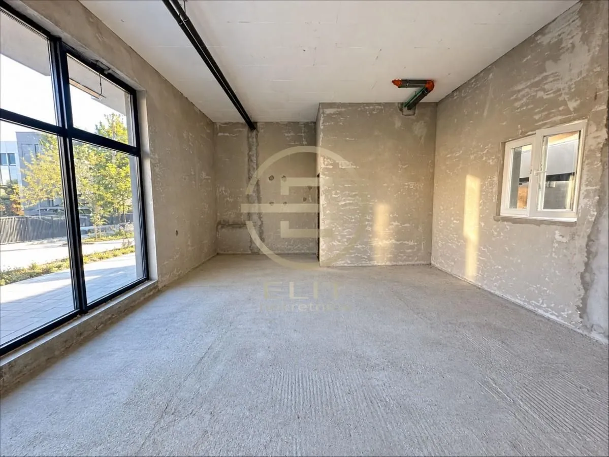 Unfinished room in grey phase with a large window.