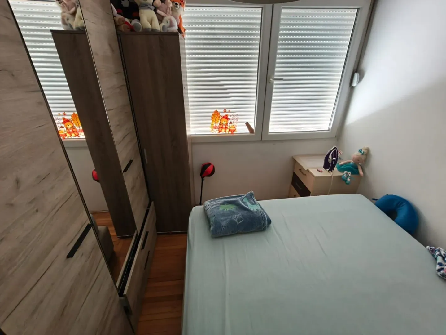 Manja spavaća soba sa krevetom i garderoberom.