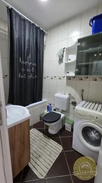 Kupatilo opremljeno tuš kabinom, umivaonikom, toaletom i veš mašinom. - image 8